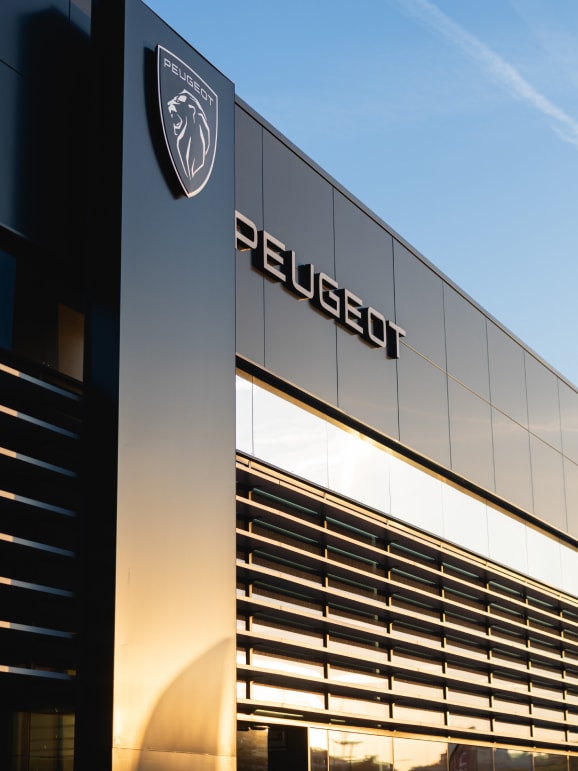 Façade d'une concession Peugeot avec logo de la marque